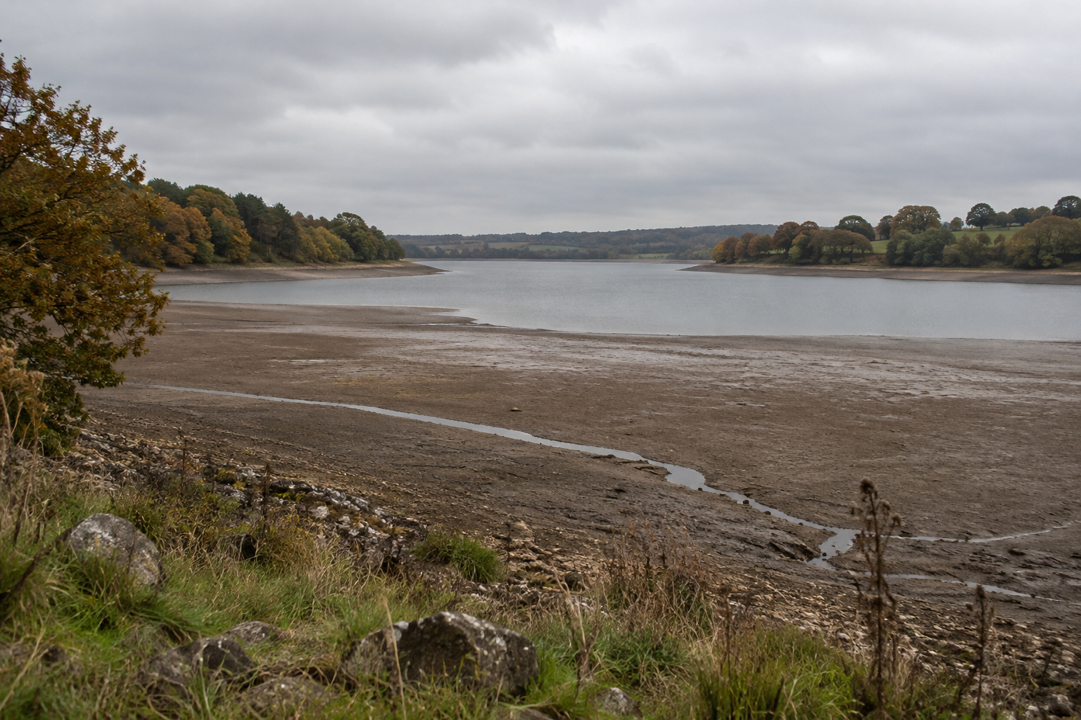 England drought leaves a broad exposed shoreline beside the reduced water surface at Ardingly reservoir.